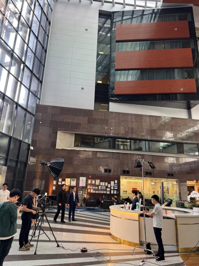 The crew sets up lights and a camera in the main lobby at Prince Court Medical Centre