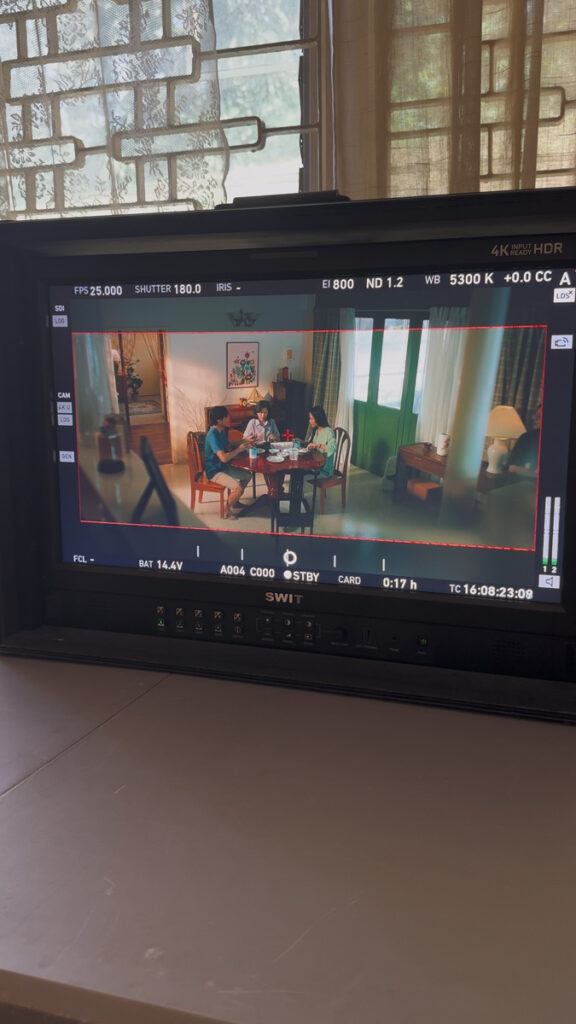 Field monitor showing a family of three at a round dinner table