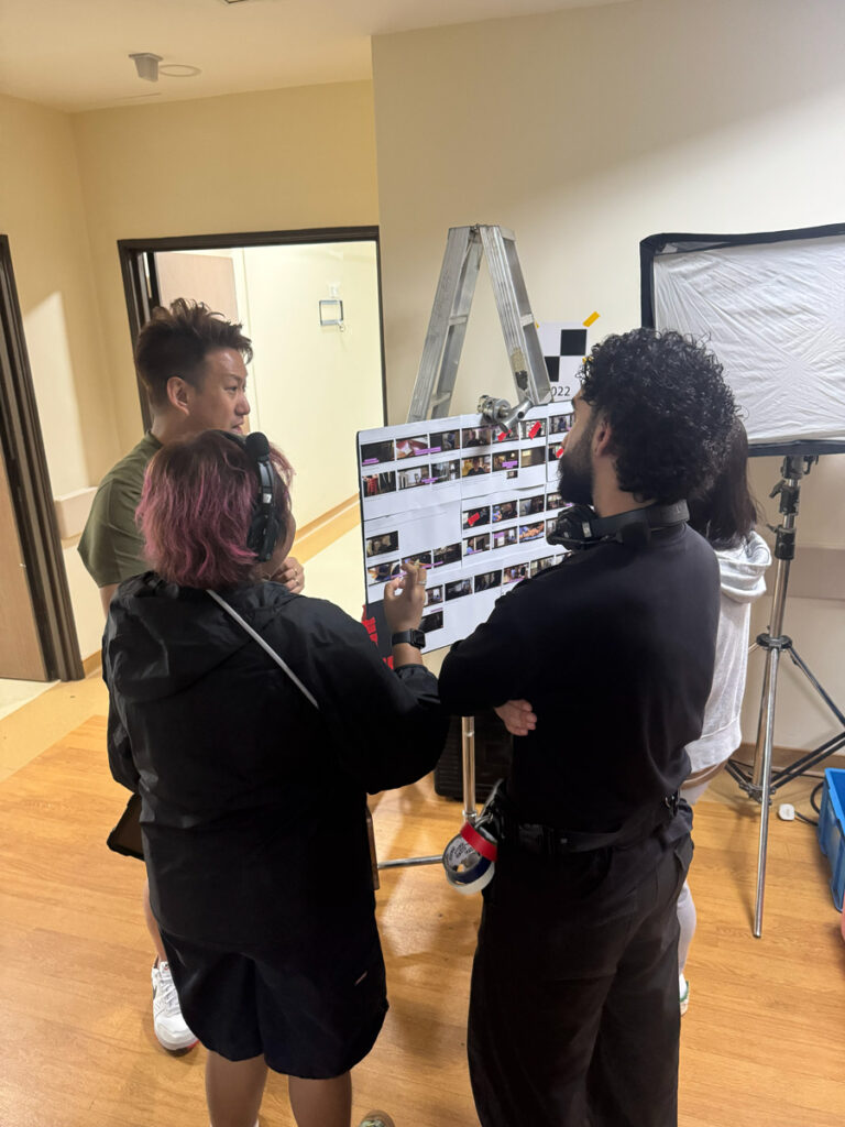 The Creo team going through a printed storyboard pinned up in a hospital corridor